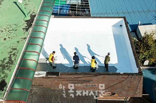 KCC 및 서울시건축사회 관계자들이 KCC의 스포탄상도(에너지) 페인트를 활용하여 시원한 옥상 만들기 작업을 하고 있다.